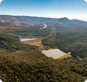 Imagem aérea da barragem B3. Há uma densa vegetação ao redor e um lado no centro. 