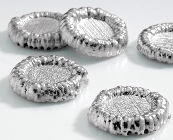 Cinco círculos achatadas de cobalto em formato de torta em cima de superfície plana. 