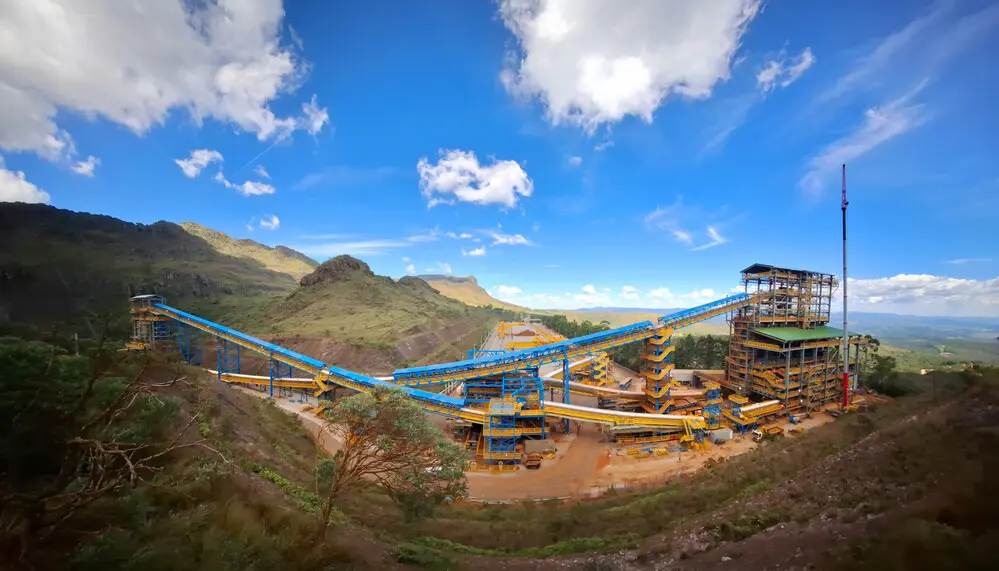 Panoramic view of Vale's Capanema Mine in Minas Gerais, Brazil, featuring iron ore processing facilities and conveyor belt structures surrounded by mountains and native vegetation. Photo: Nayara Leite.