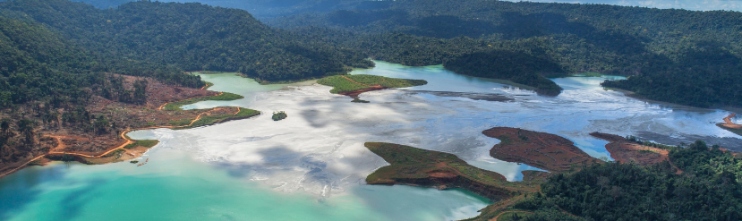 foto vista de cima com água no meio da imagem e montanhas e terras em volta