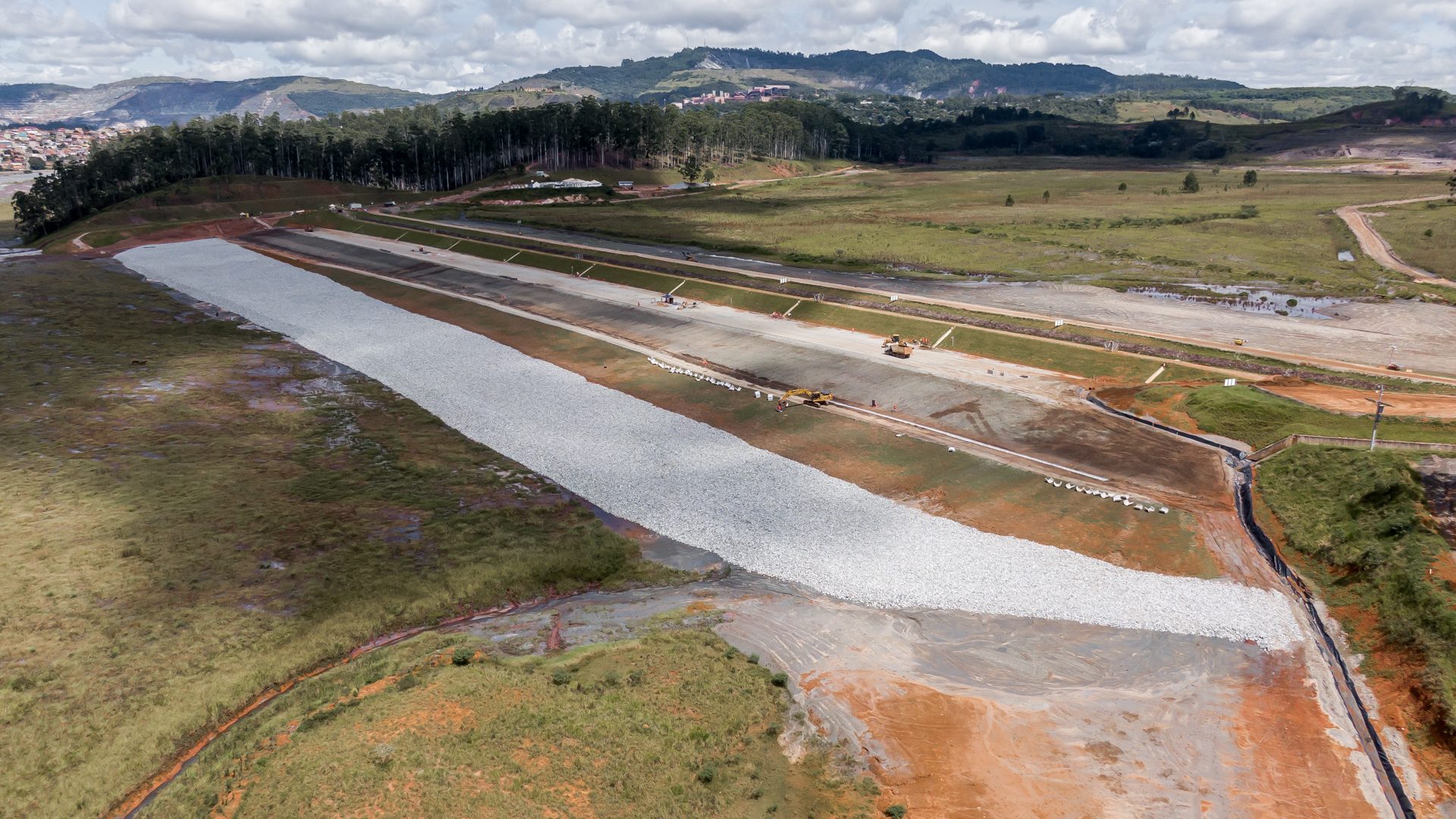 Imagem de cima de uma área com vegetação e obra ao redor 