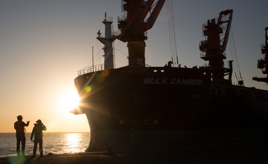 Employees side by side with a ship