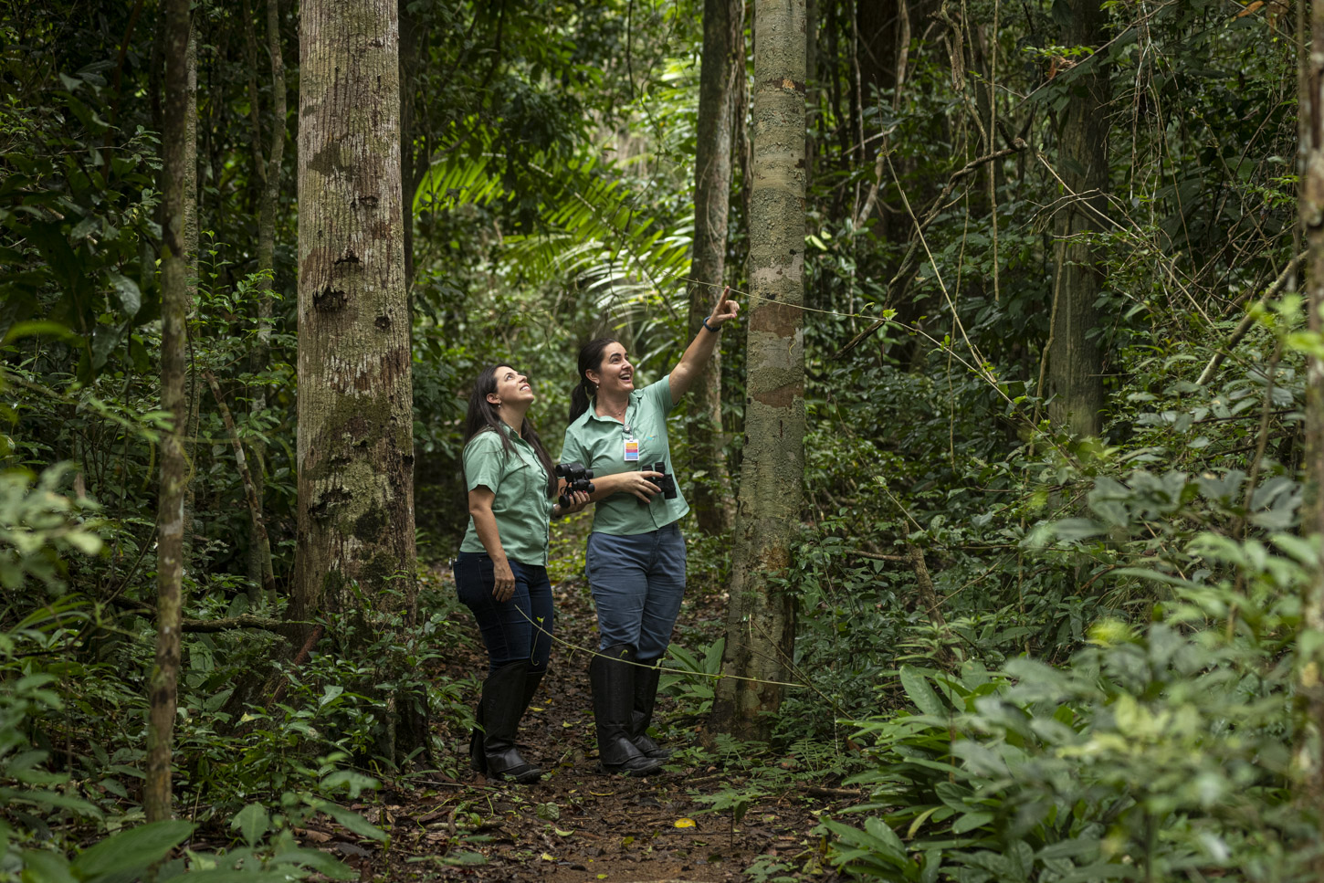 Duas pessoas entre árvores caminhando no parque botânico