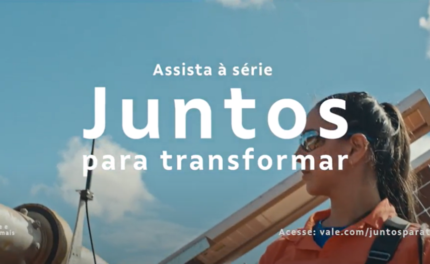 Foto de uma mulher branca de cabelo escuro liso amarrado, óculos escuros com um painel de luz solar e céu ao fundo.