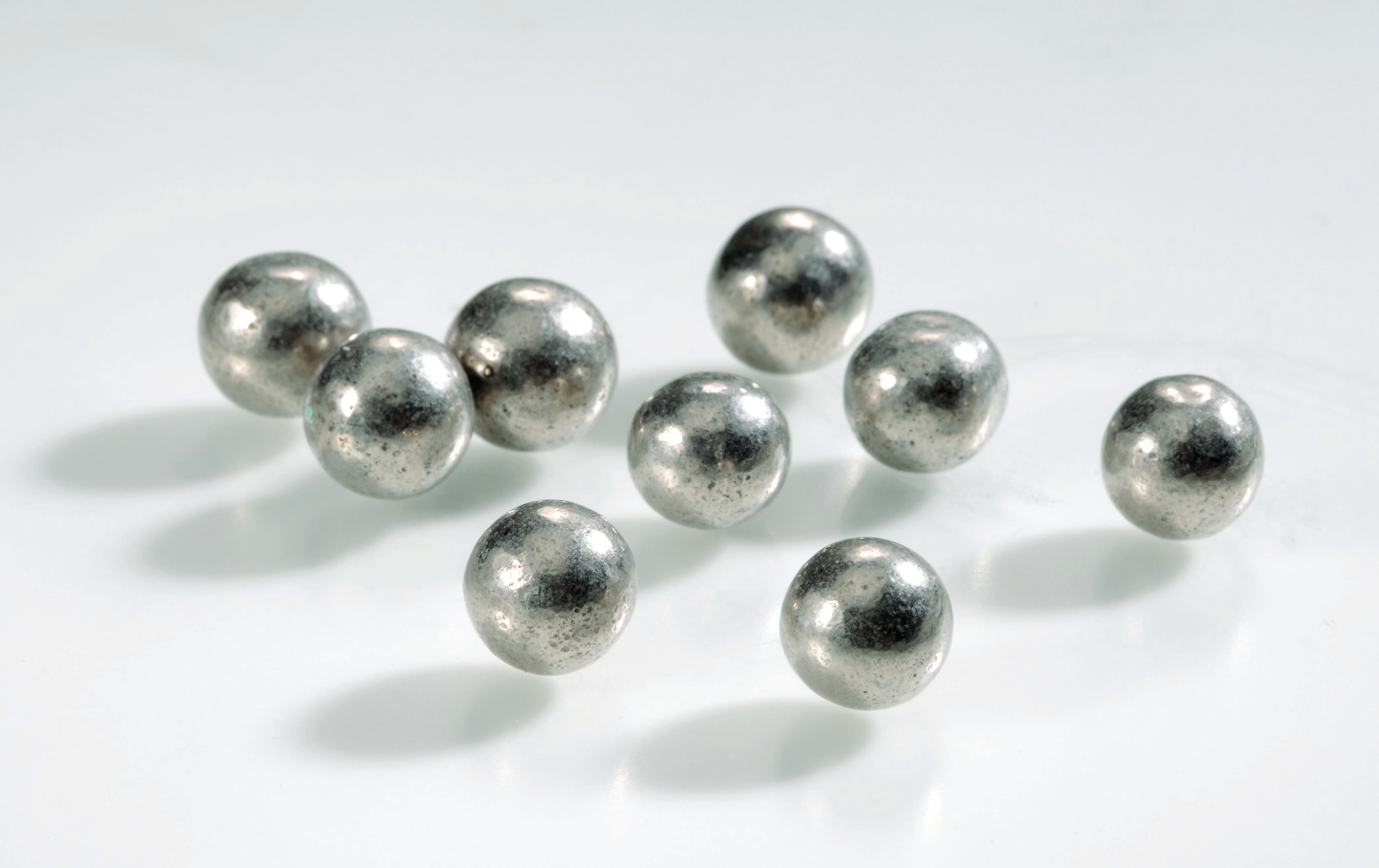 Nove círculos de metal de diversos tamanhos distribuídos em superfície plana. 