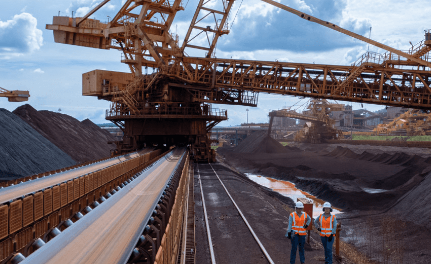 Outside operating area with large machinery. There are two employees in the space.